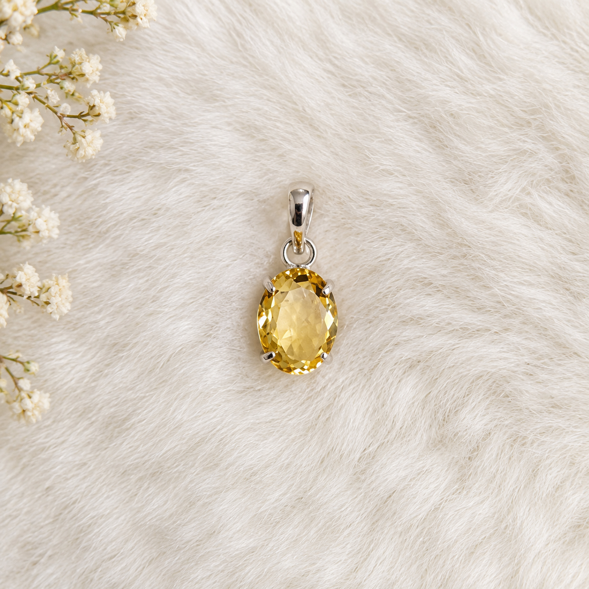 Citrine pendant displayed on a soft cream background with floral accents, featuring a golden oval citrine crystal, benefits for positivity, confidence, abundance and energy,