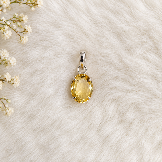 Citrine pendant displayed on a soft cream background with floral accents, featuring a golden oval citrine crystal, benefits for positivity, confidence, abundance and energy,