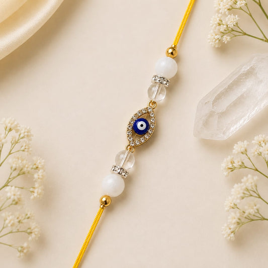 Handmade Crystal Rakhi with White Crystal and Clear Quartz beads, an elegant Evil Eye charm, and yellow thread. Premium Raksha Bandhan Rakhi symbolizing love, protection, peace, and positive energy, available for ₹300.